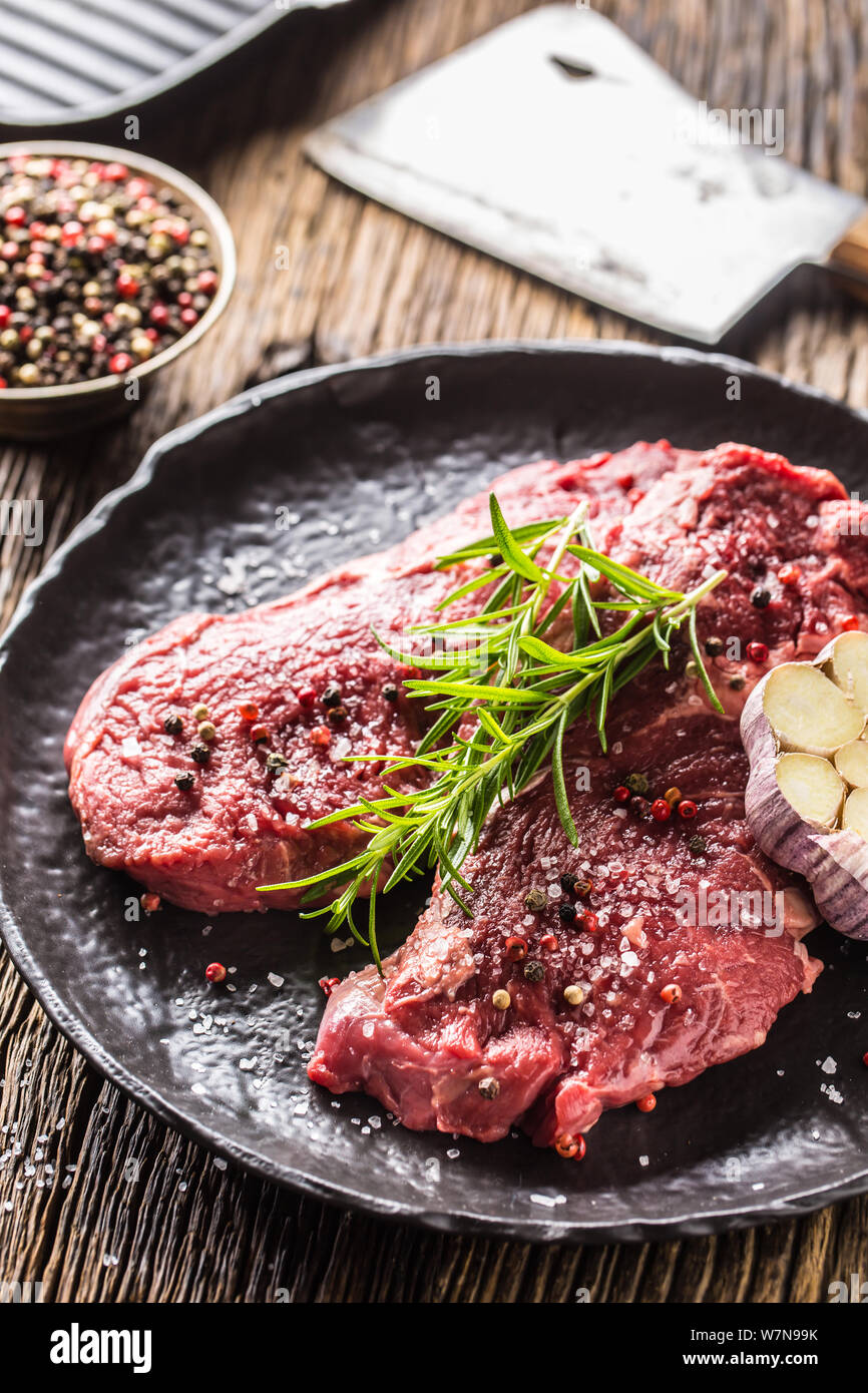 Beef meeat Rib-Eye steak wit rosemary salt and pepper on black plate Stock Photo