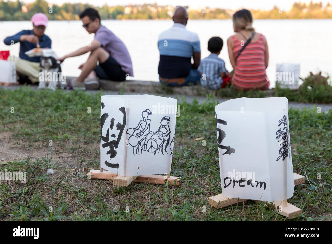Participants gather by the lake at the Toro Nagashi Lantern Floating Ceremony in Seattle, Washington on August 6, 2019. “From Hiroshima To Hope” is held in remembrance of atomic bomb victims on the anniversary of the bombing of Hiroshima, Japan. The ceremony, organized by a collation of peace, religious, civil liberties and cultural heritage organizations, honors victims of the bombings of Hiroshima and Nagasaki, and all victims of violence. It is an adaptation of an ancient Japanese Buddhist ritual, the Toro Nagashi, in which lanterns representing the souls of the dead are floated out to sea Stock Photo
