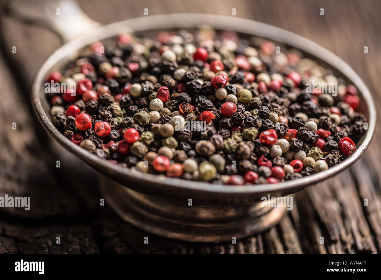 Mixed peppercorns red black and white in bowl Closeup Stock Photo