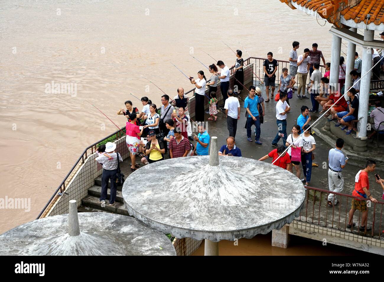 Local residents visit the bank of the flooded Xijiang River caused by heavy rains in Wuzhou city, south China's Guangxi Zhuang Autonomous Region, 4 Ju Stock Photo