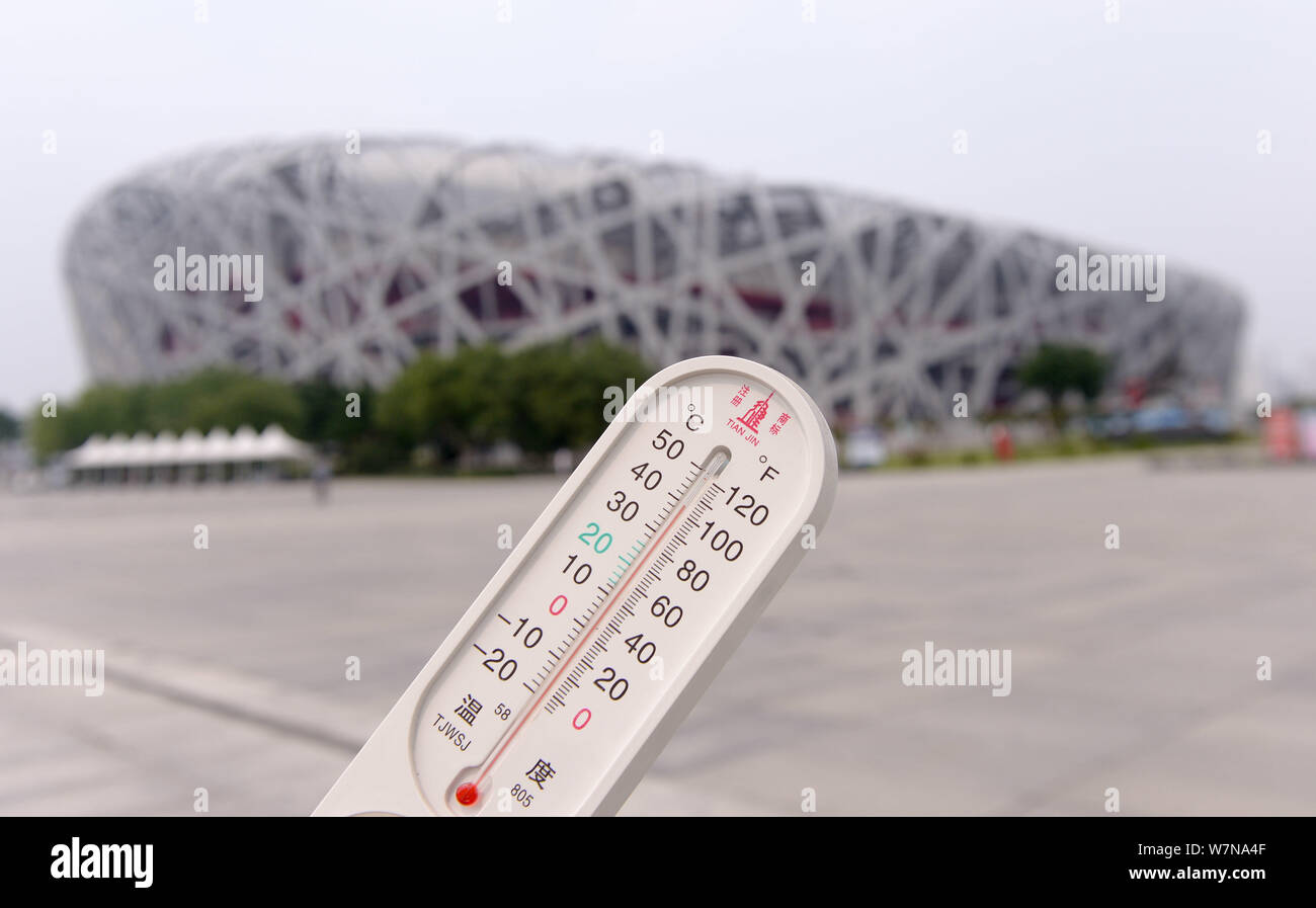 A local resident displays a thermometer showing the current temperature reaching 40 degrees Celsius on a scorching day in front of the Beijing Nationa Stock Photo