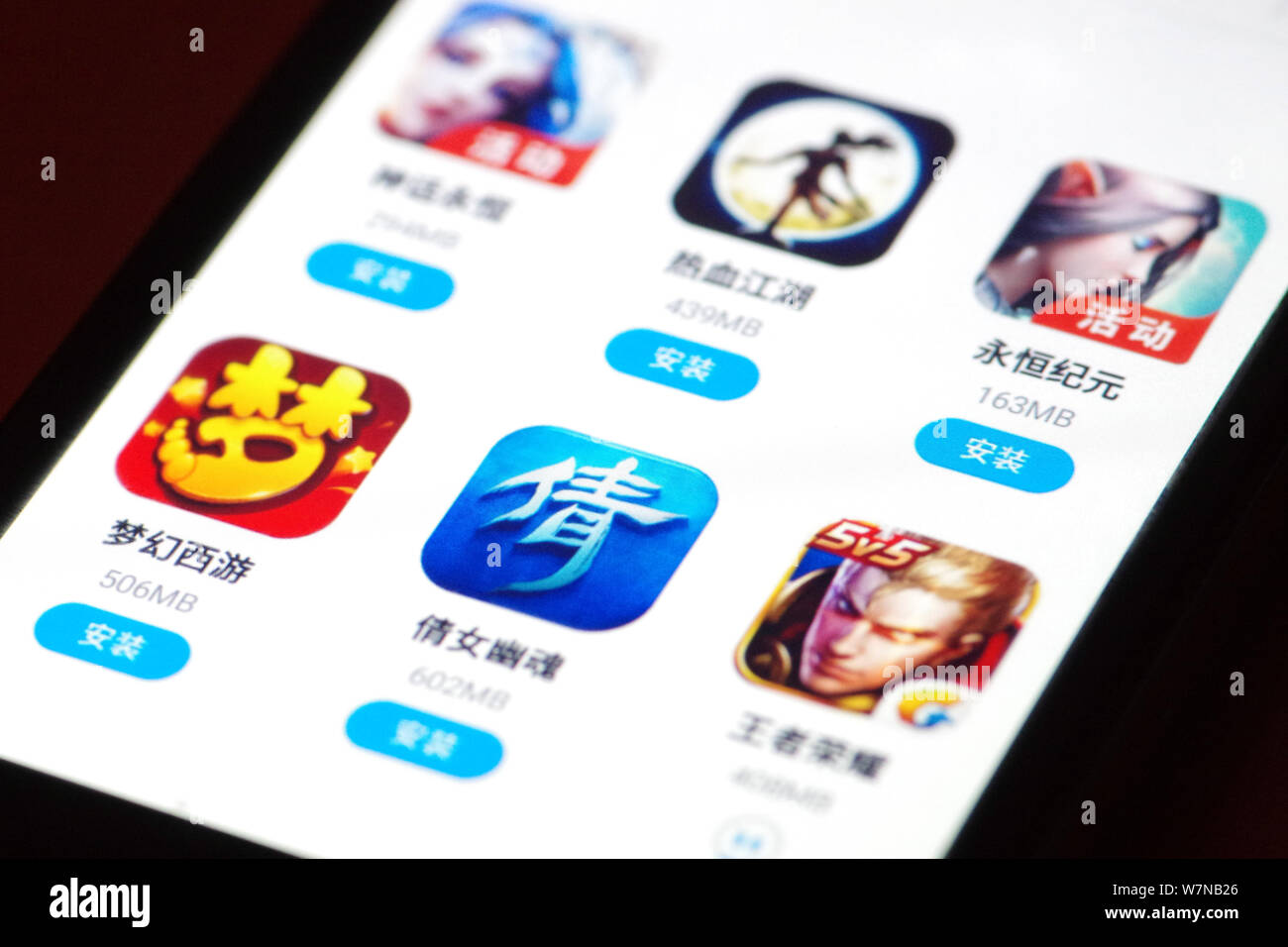 --FILE--A mobile phone user shows icons of mobile game apps on his ...