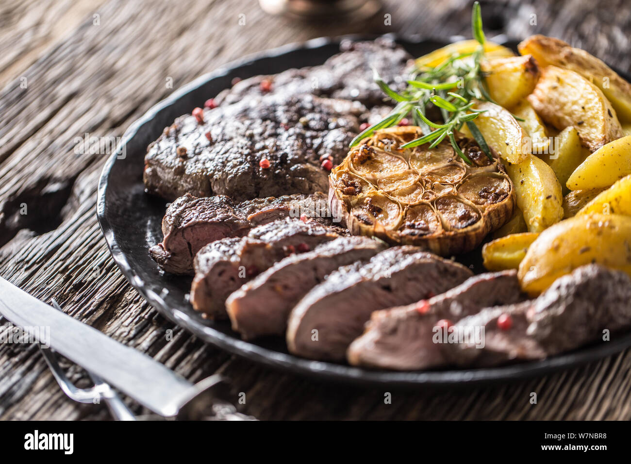 Grilled beef Rib Eye steak with garlic american potatoes rosemary salt and spices Stock Photo