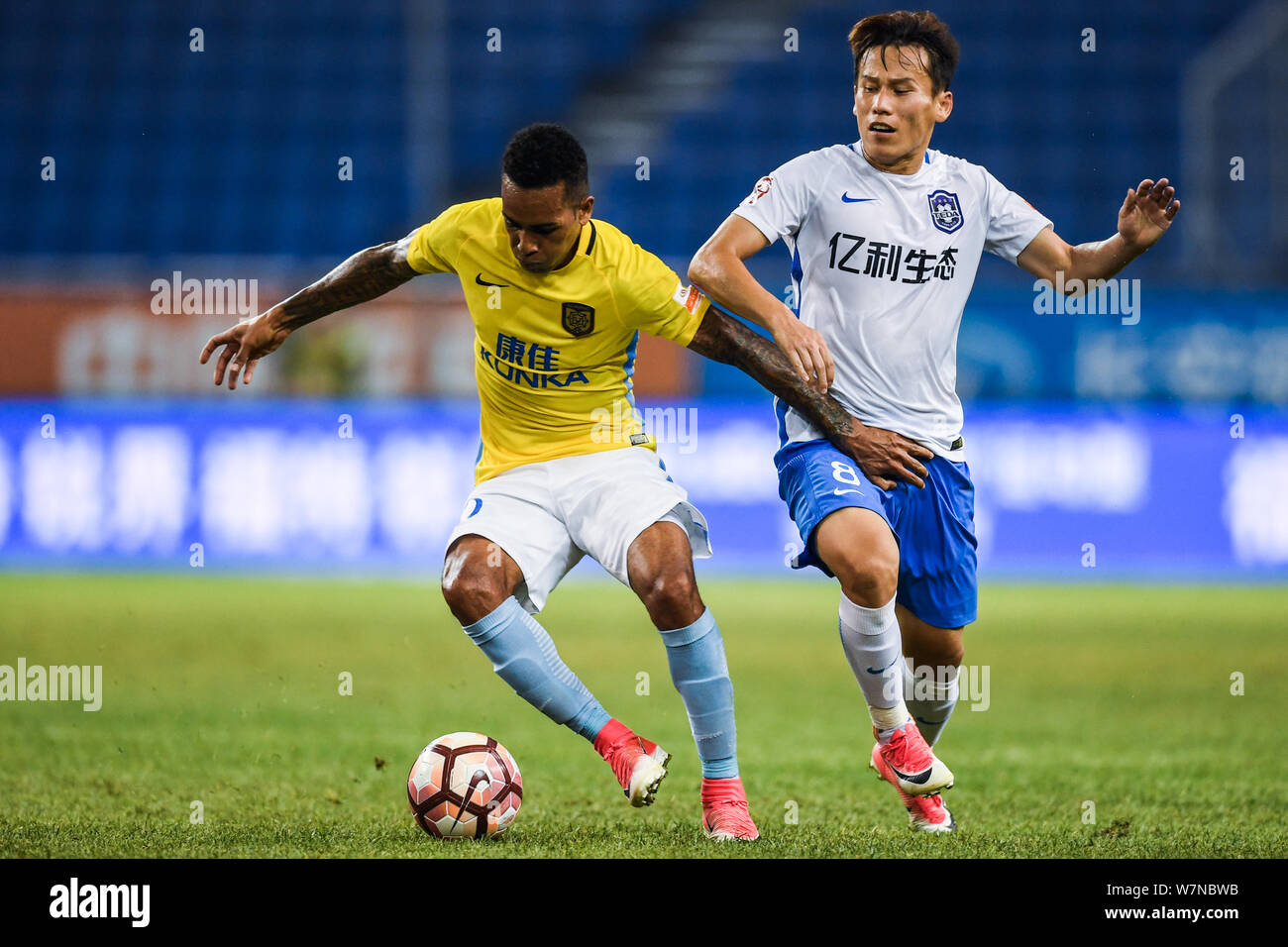 Brazilian football player Alex Teixeira, left, of Jiangsu Suning, challenges Hu Rentian of Tianjin TEDA in their 17th round match during the 2017 Chin Stock Photo