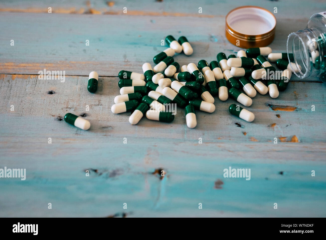 Bottle of medicine pills on a woden table . concept of drugs and