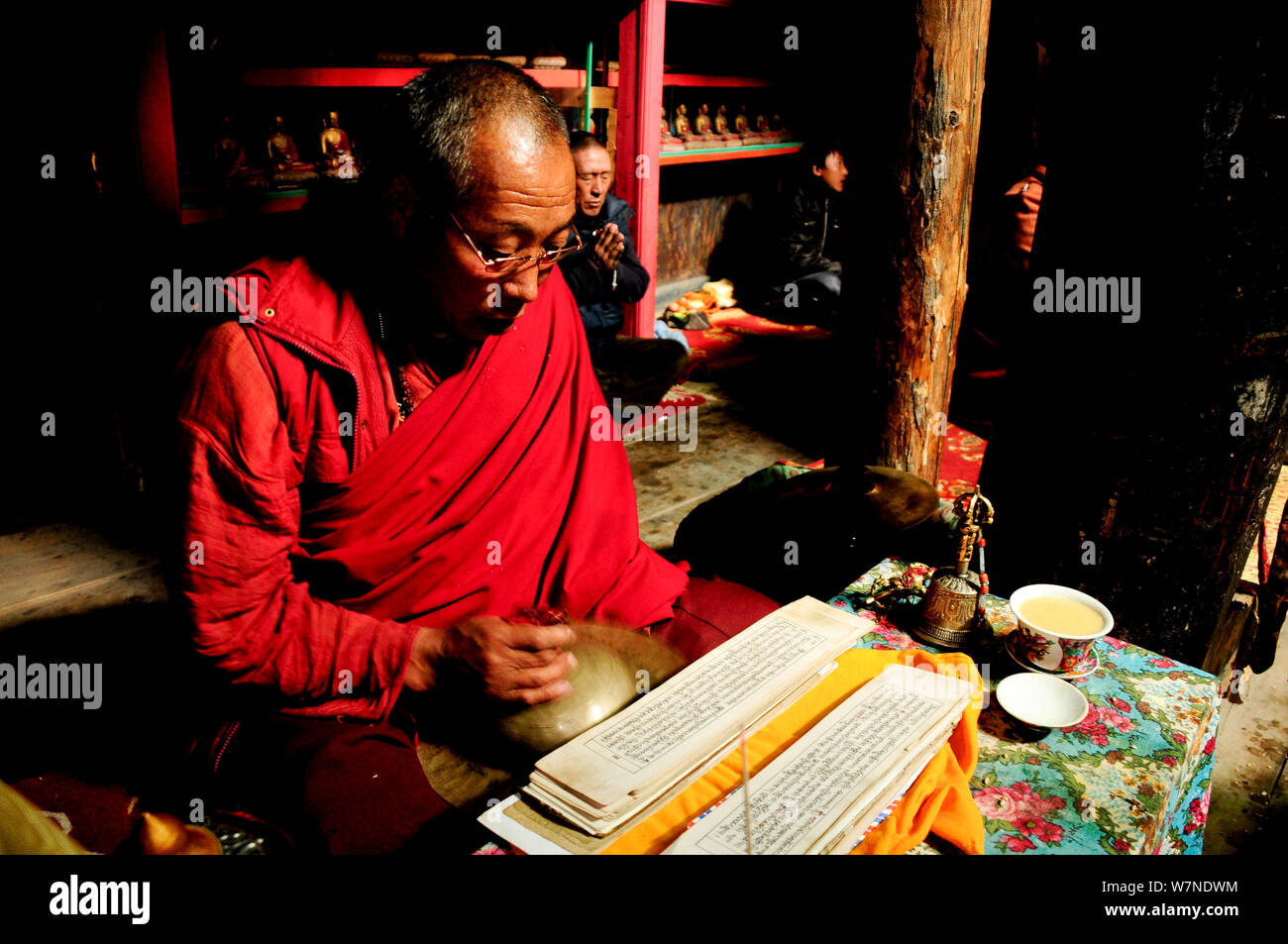 Bhojo Buddhist monastery with monk reading sacred text (3.500m), Manang. Annapurna Conservation Area, Himalayas, Nepal, October 2009. Stock Photo