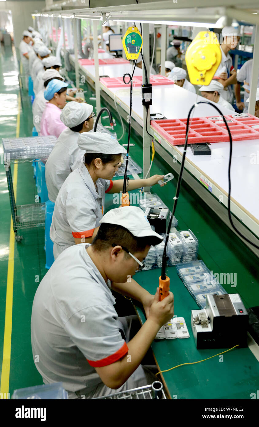 --FILE--Chinese workers produce electronic products on the assembly line at a factory in Huaying city, southwest China's Sichuan province, 12 July 201 Stock Photo