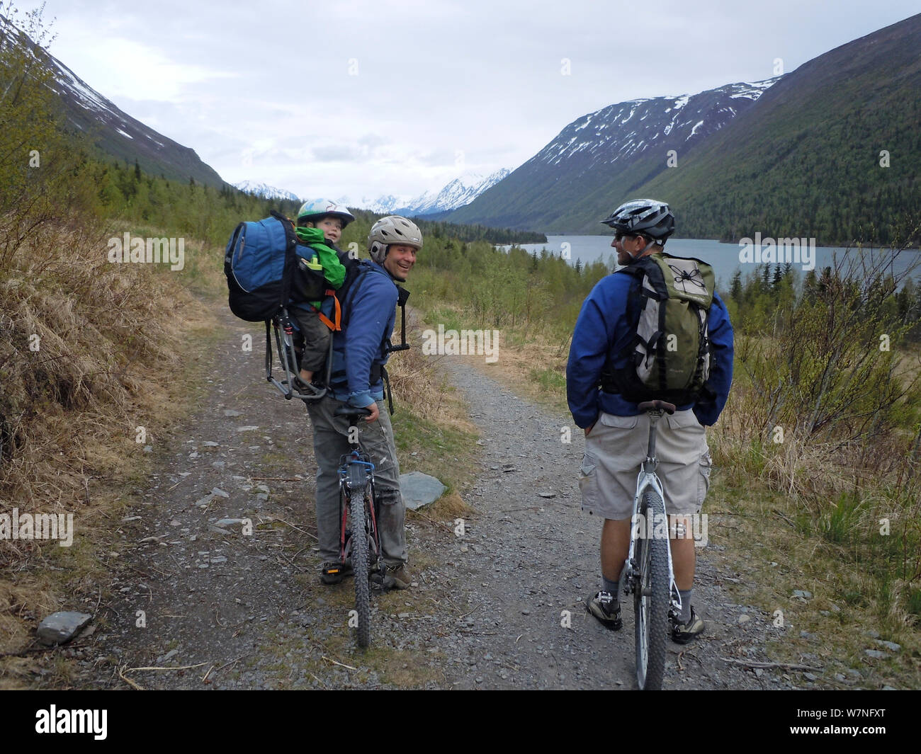 Two men and a toddler take a break from mountain biking on the Russian River Falls trail. Kenai National Wildlife Refuge, Chugach National Forest, Alaska, May 2012. Stock Photo