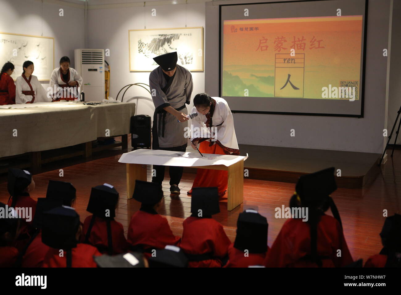 Students learn to write the Chinese character "Ren," meaning "Human" in