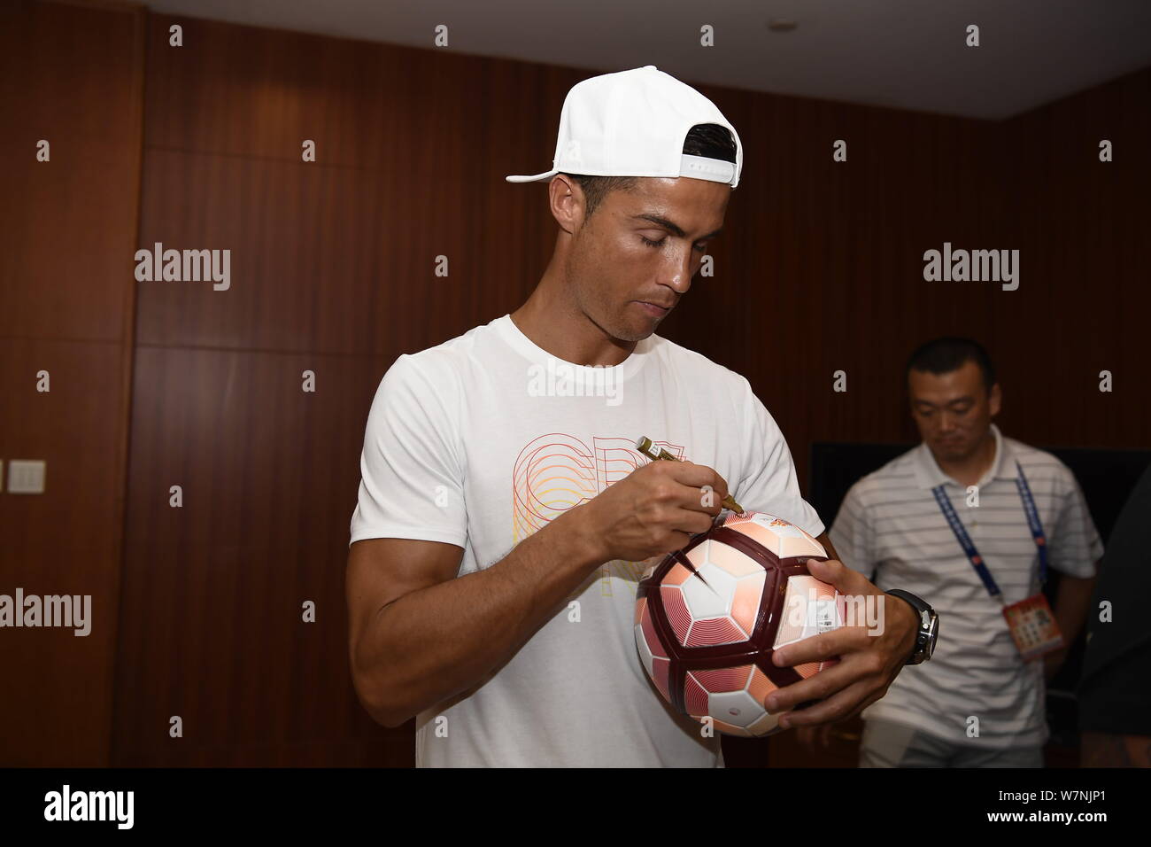 Portuguese football player Cristiano Ronaldo of Real Madrid signs an autograph on a football 
