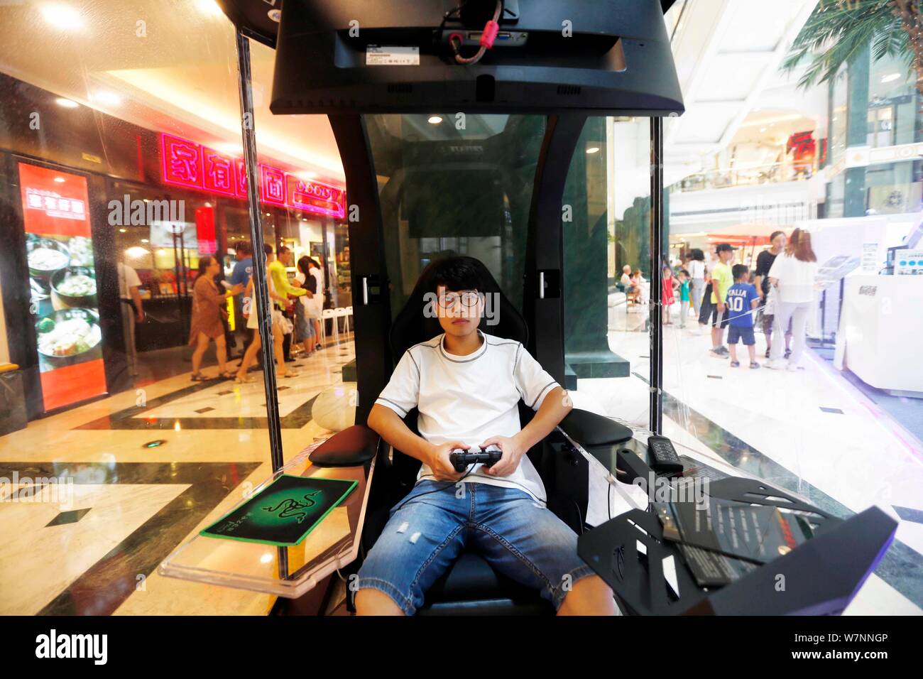 A Chinese man plays video games in a private lounge of "Waiting For You In  The Bar," facilities for bored husbands to enjoy themselves while their wiv  Stock Photo - Alamy