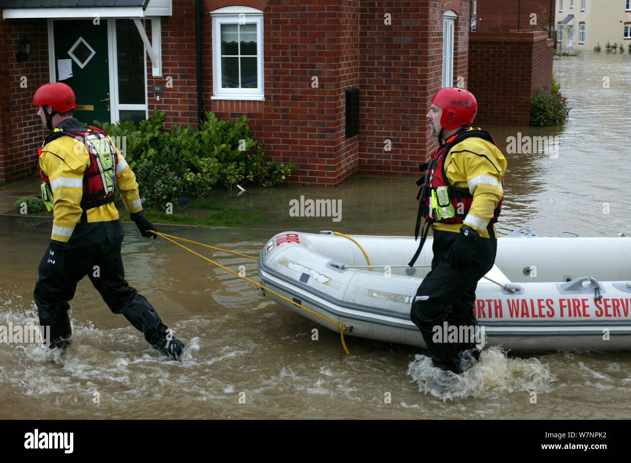 Members of north wales fire service with boat to rescue people affected by flooding of newly built housing in the Glasdir estate, Ruthin, Vale of Clwyd, Denbighshire, Wales, UK.  This is an area at risk of flooding and therefore difficult to obtain House insurance. 27/11/ 2012 Stock Photo