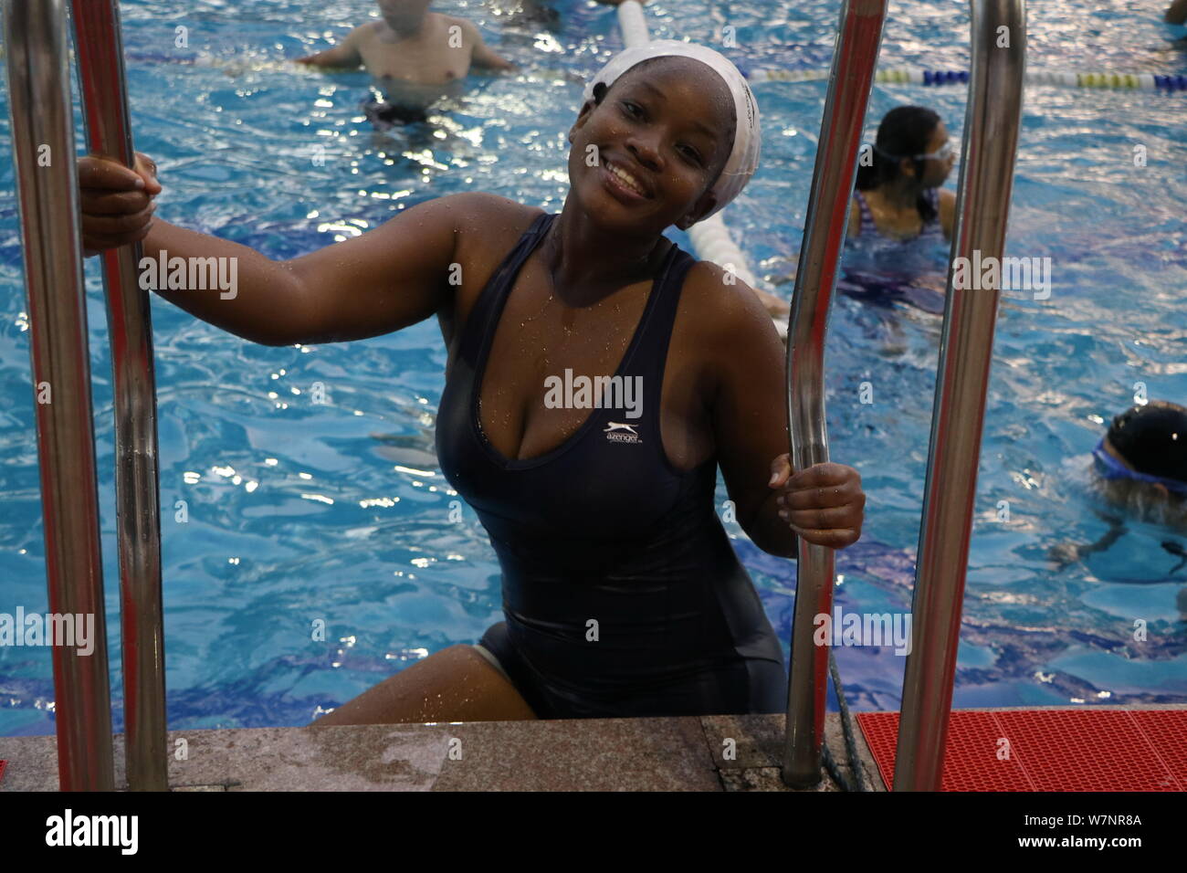 An African student enjoys herself to cool off at a swimming pool on a scorching day in Fuzhou city, southeast China's Fujian province, 23 July 2017. Stock Photo