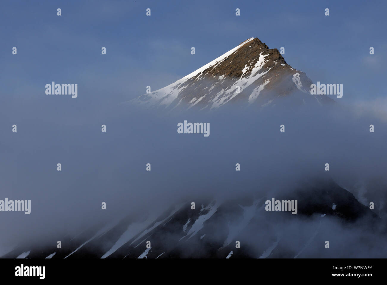 Mountain with peak above clouds, Svalbard, Norway July 2011 Stock Photo