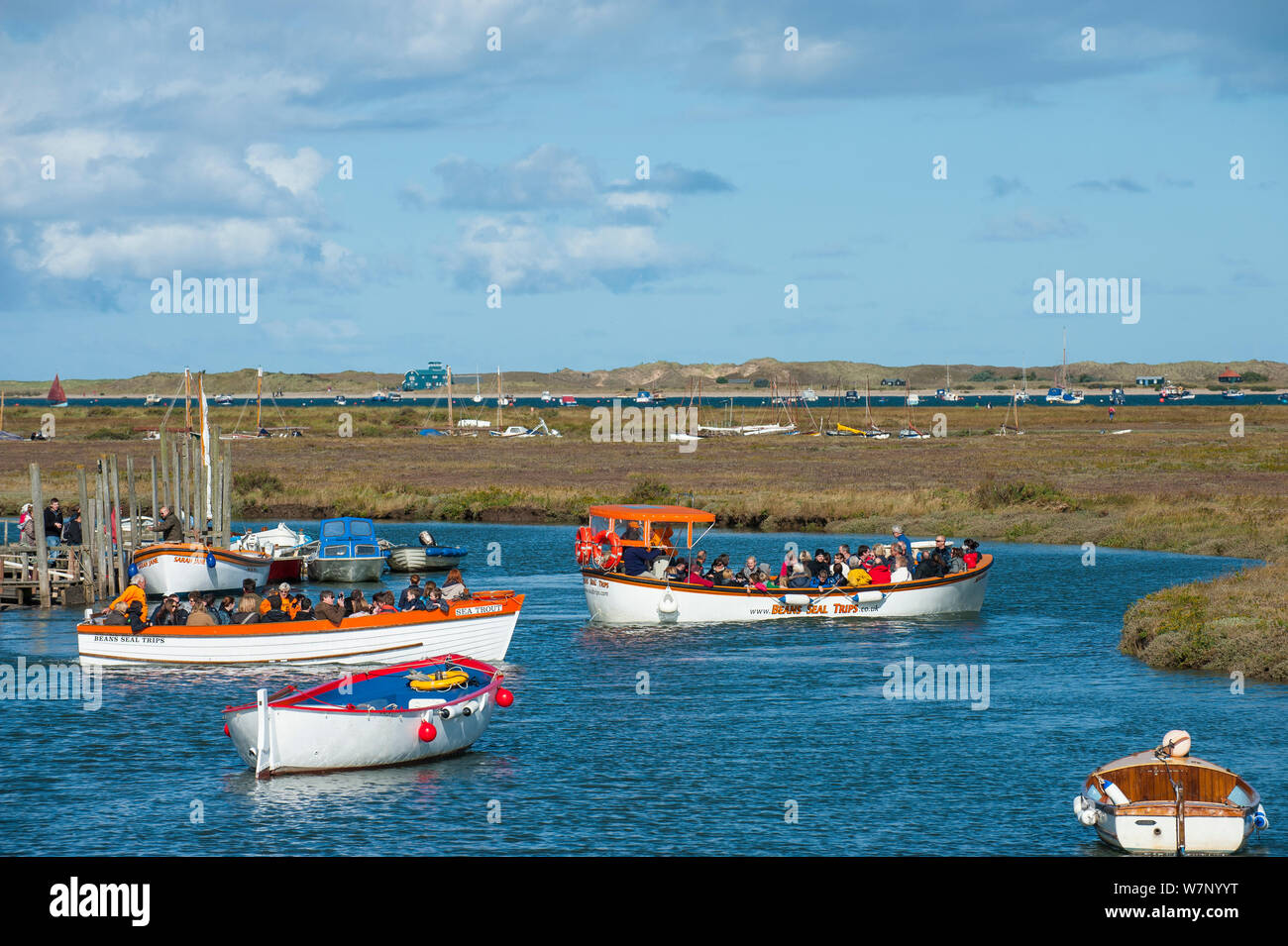 Morston Quay with boats containing tourists leaving to view the seals at Blakeney Point, Norfolk, England, September 2012 Stock Photo