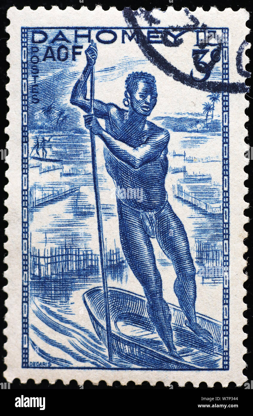 Fisherman on small canoe in stamp of Dahomey Stock Photo