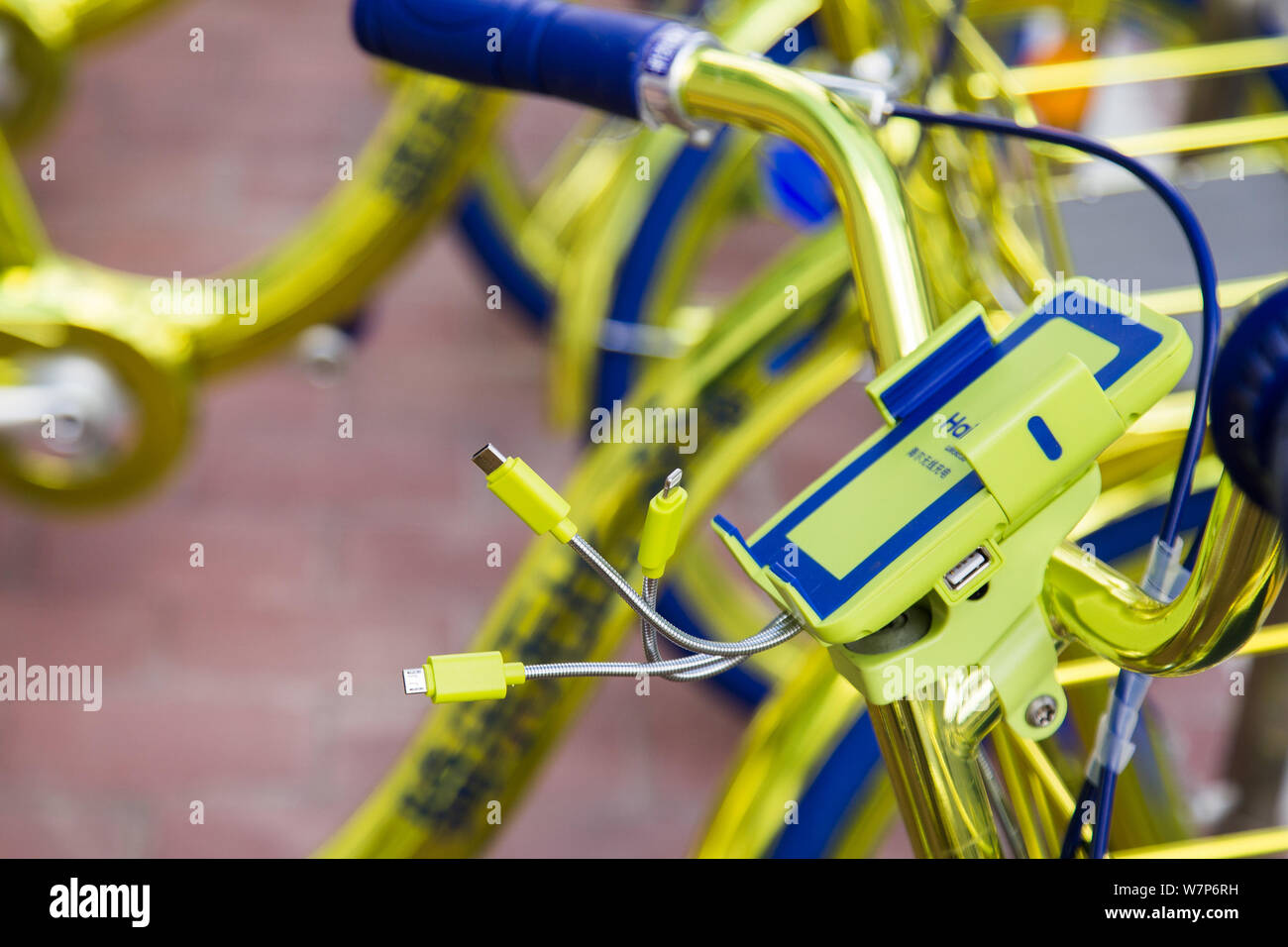 A phone holder is seen on a golden bicycle of Chinese bike-sharing service Coolqi in Shenzhen city, south China's Guangdong province, 8 June 2017.   T Stock Photo