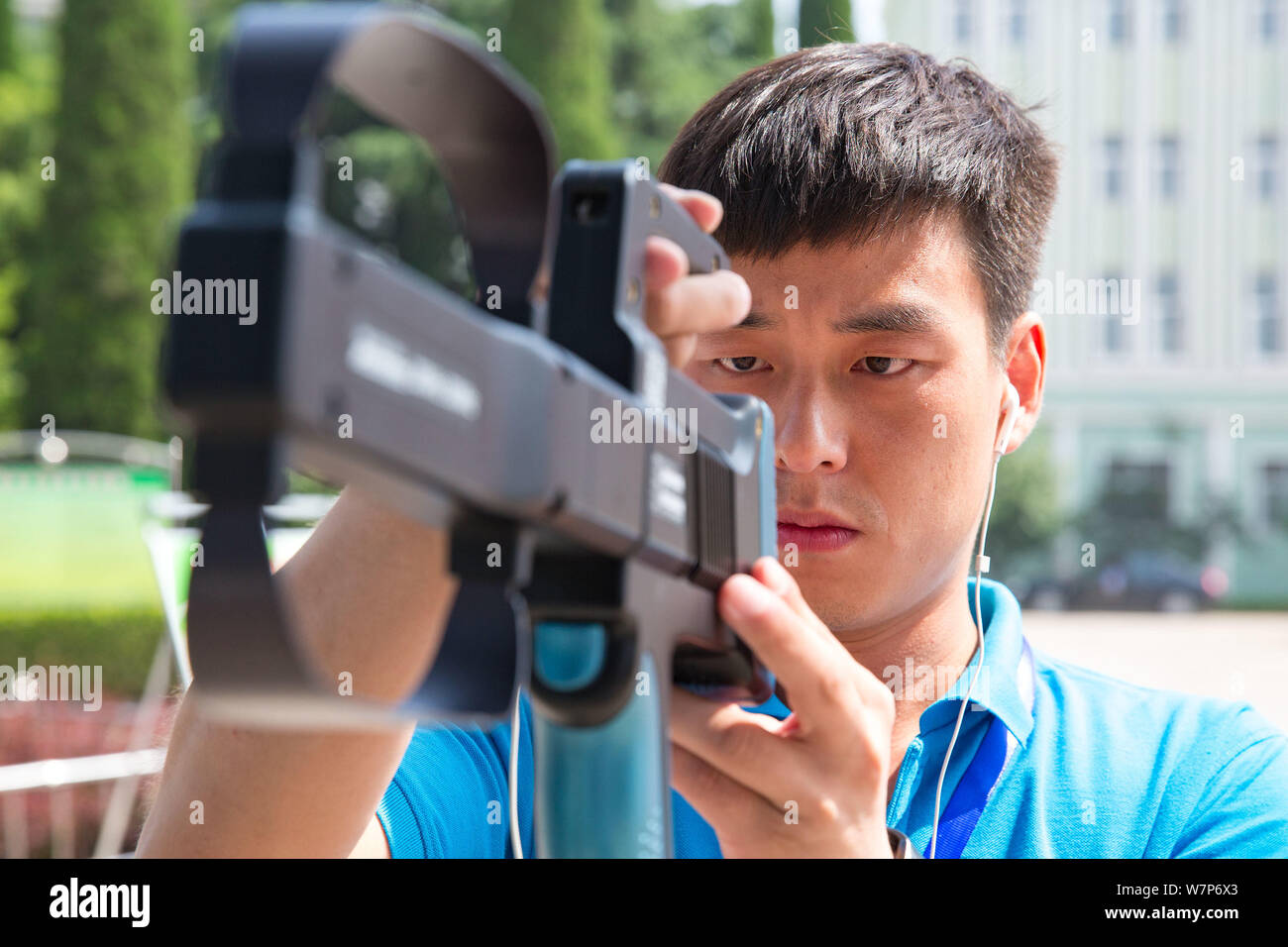 A Chinese inspector uses an anti-cheating device to monitor radio signal during the 2017 National College Entrance Exam, also known as gaokao, at a sc Stock Photo