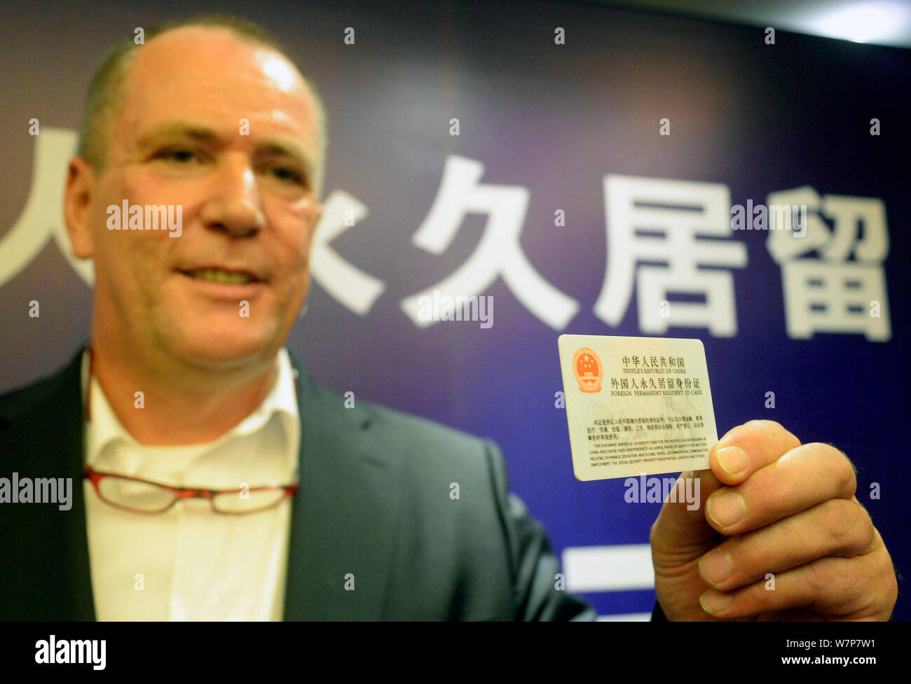 A foreigner shows his Permanent Resident ID Card during the launch ceremony to replace green cards for foreigners with 'smart cards' held in Hangzhou Stock Photo