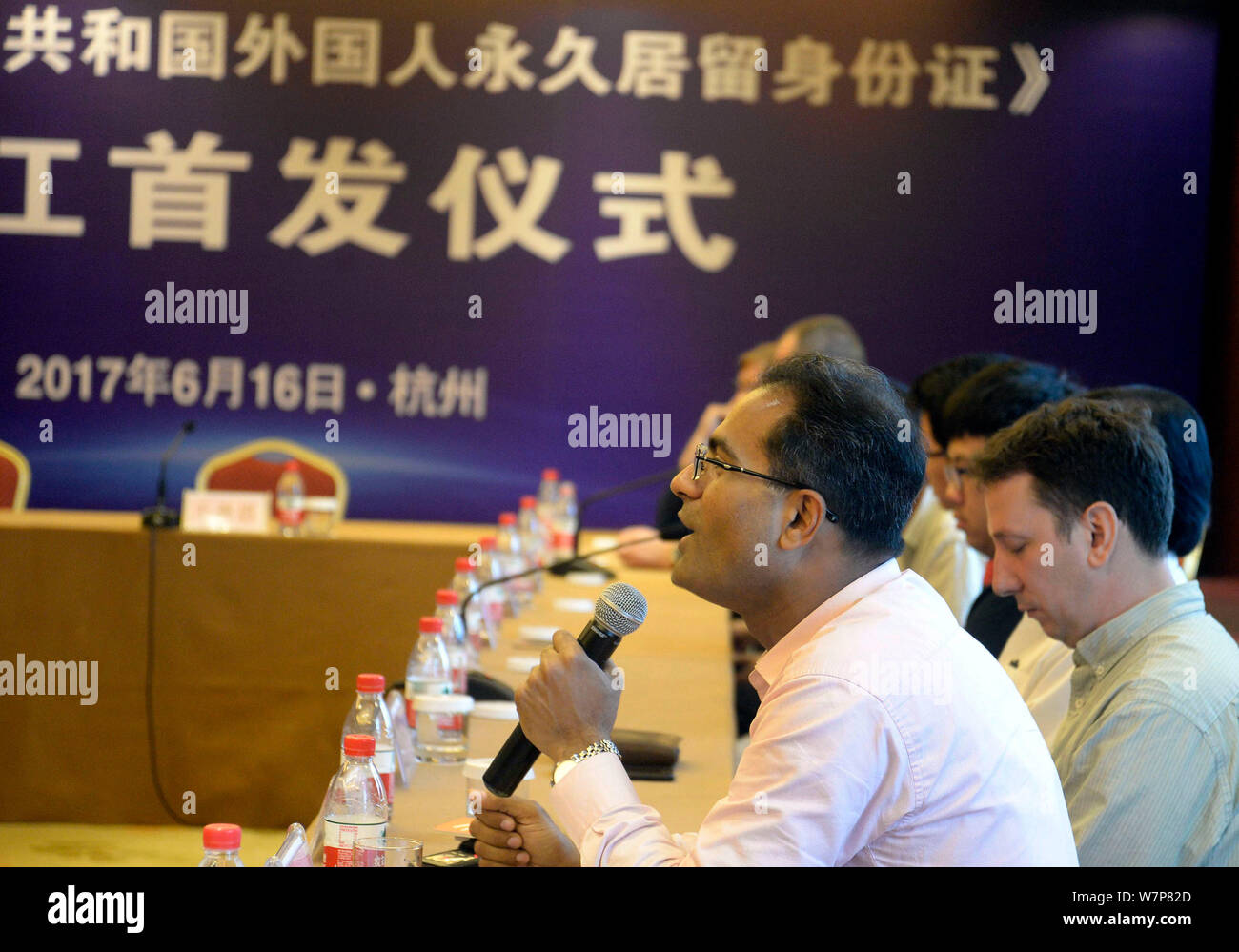 Foreigners speak during the launch ceremony to replace green cards for foreigners with 'smart cards' held in Hangzhou city, east China's Zhejiang prov Stock Photo
