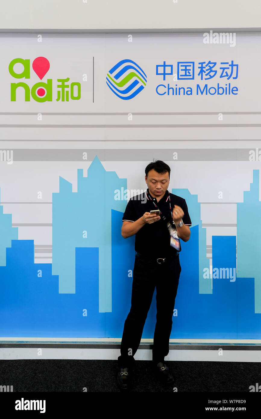 A visitor uses his smartphone at the stand of China Mobile during the 2017 Mobile World Congress (MWC) in Shanghai, China, 28 June 2017.   The Mobile Stock Photo