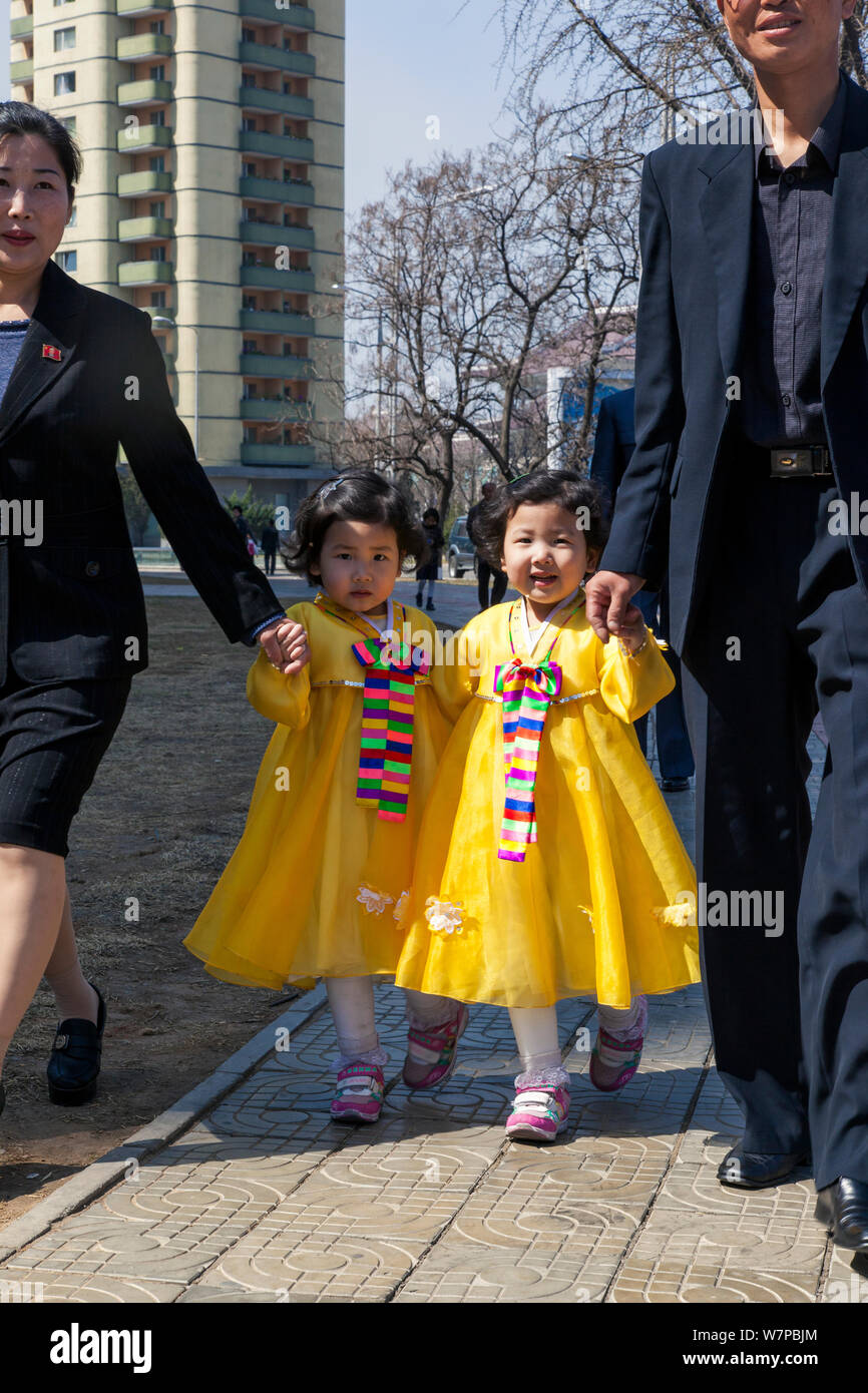 Young girls in colourful traditional dress walking along pavement in Pyongyang, Democratic Peoples' Republic of Korea (DPRK), North Korea, 2012 Stock Photo