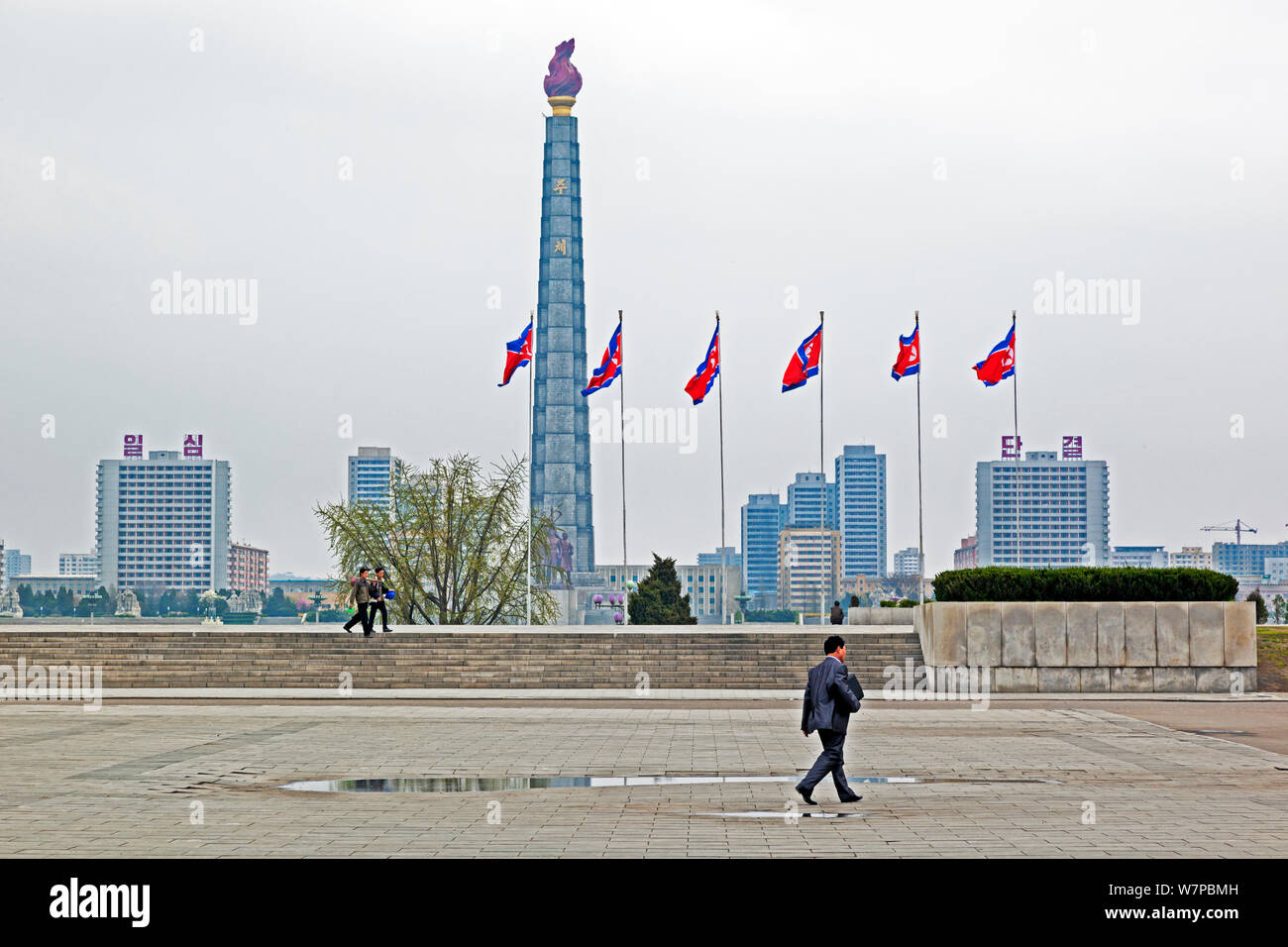 Man walking infront of Juche Tower and the Taedong river, Pyongyang, Democratic Peoples' Republic of Korea (DPRK), North Korea, 2012 Stock Photo