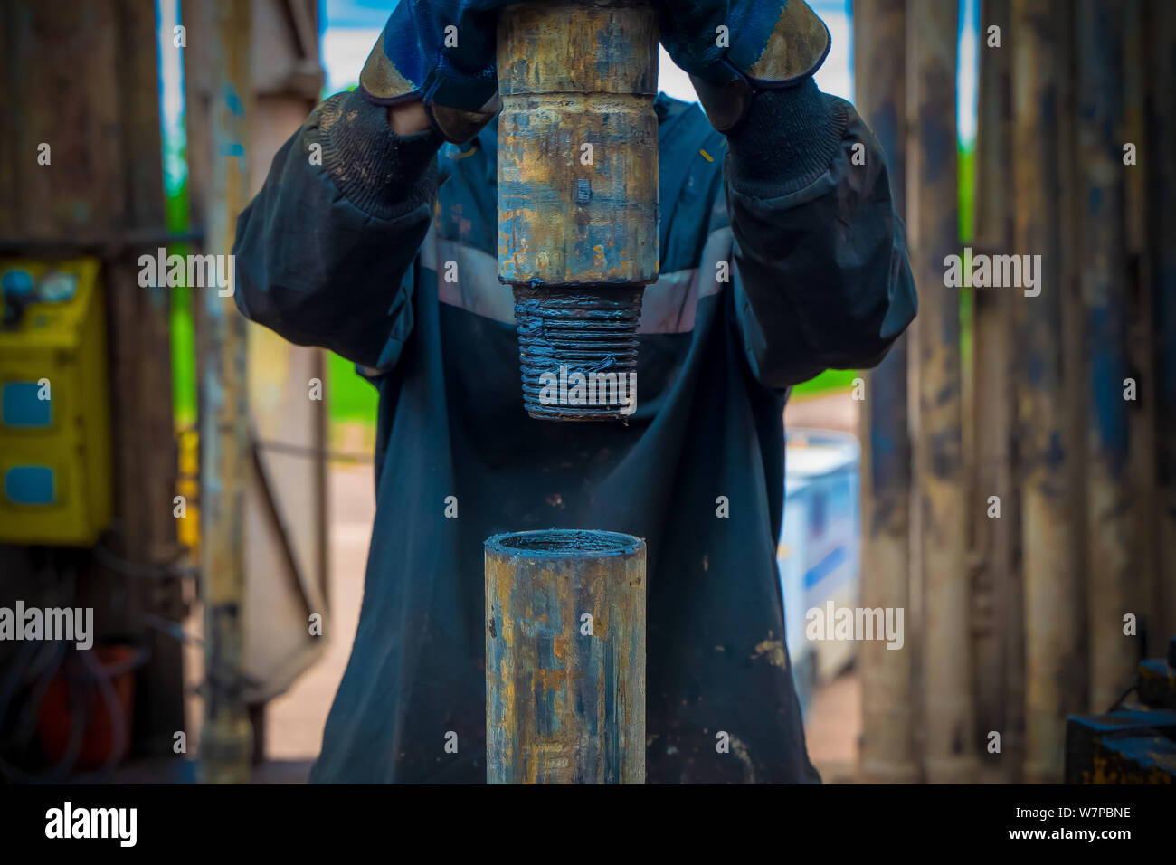 Offshore oil rig worker prepare tool and equipment for perforation oil and gas well at wellhead platform. Making up a drill pipe connection. A view fo Stock Photo