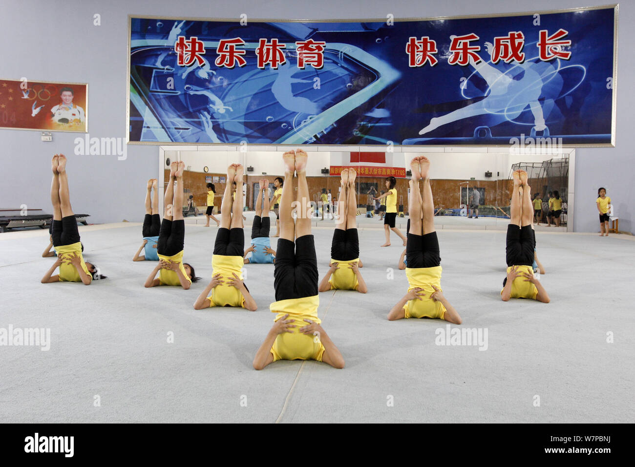 Young Chinese girls bend their bodies to practice gymnastics at a gymnastics and diving training center in Nanchang city, east China's Jiangxi provinc Stock Photo