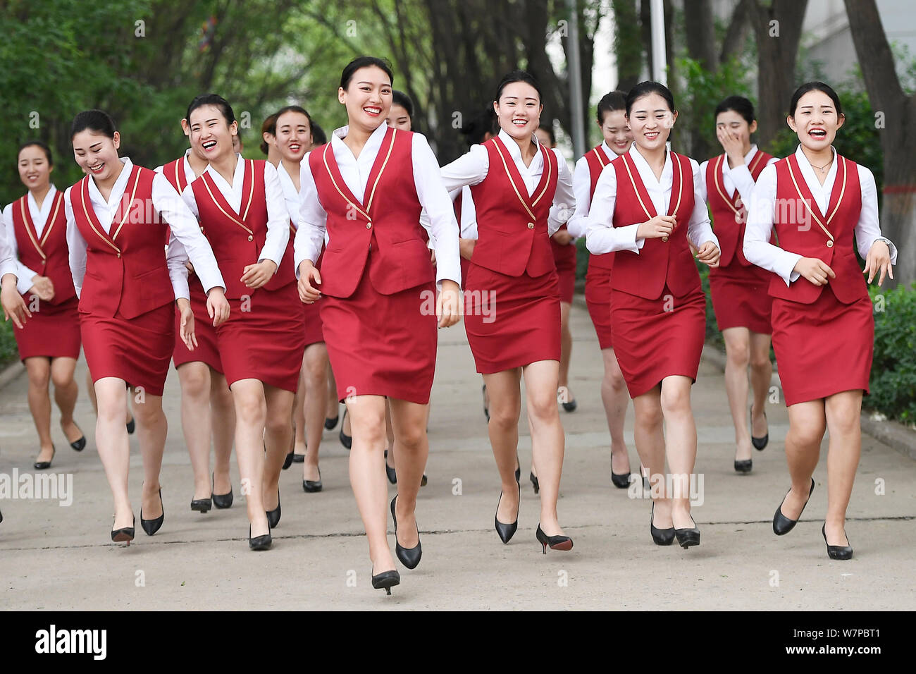 Female graduates of flight attendants major dressed in air hostess uniforms, pose for gradation photos in Taiyuan city, north China's Shanxi province, Stock Photo