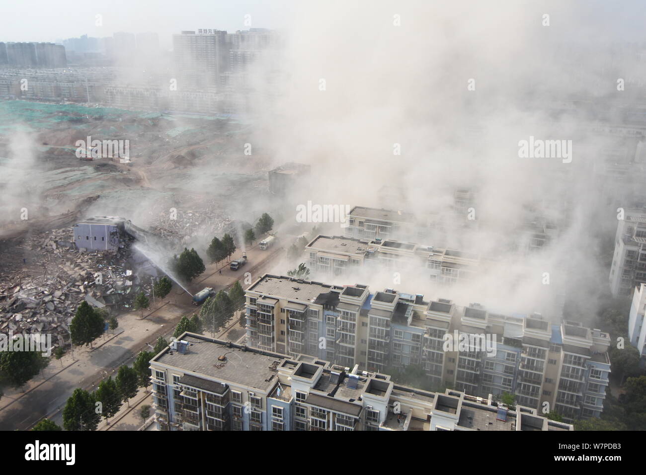 Trucks equipped with water cannons are set up to lower dense smoke after six buildings ranging from 7 to 12 storeys high and covering 20,000 square me Stock Photo
