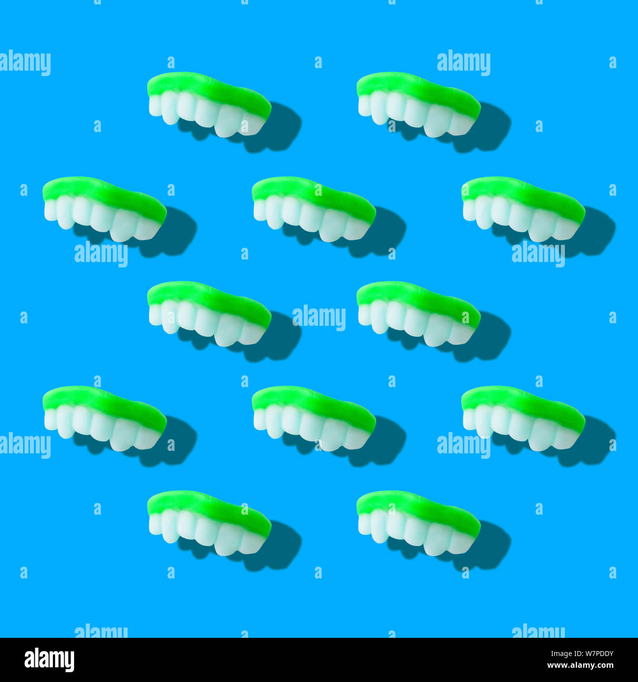 Photography collage of neon green color gummy milk teeth or jelly sweets on pastel blue background top view flat lay isometric pattern Stock Photo