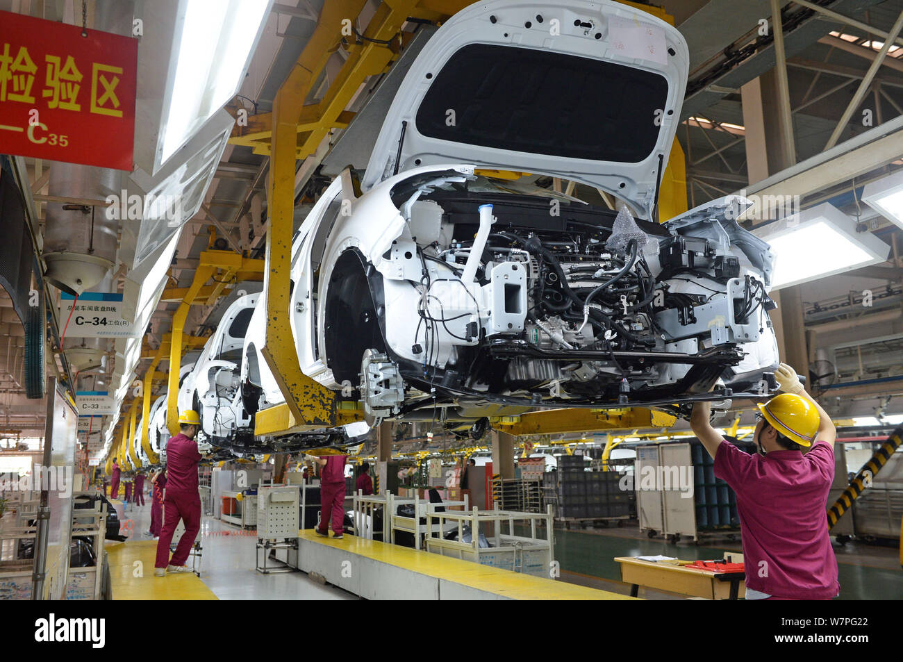 Chinese workers assemble a car on the assembly line at the auto plant ...