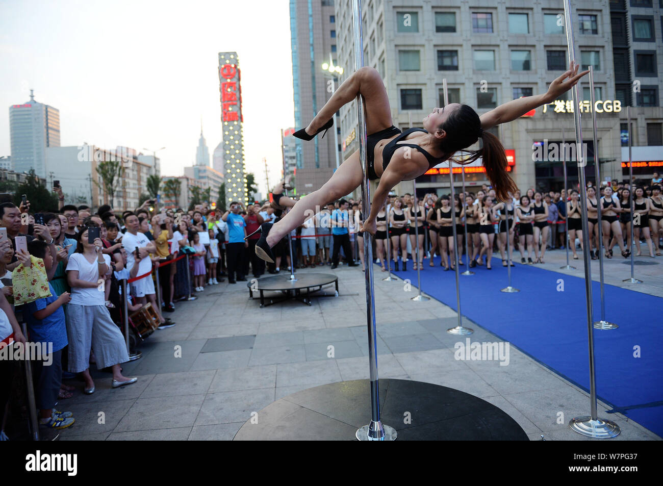 A Chinese woman performs pole dancing on a square in Ji'nan city, east China's Shandong province, 17 June 2017.   Square dancing does not belong to Ch Stock Photo