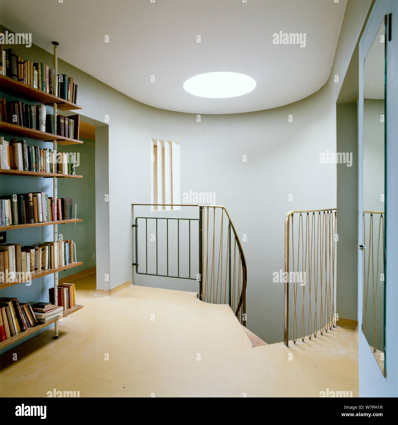 Bookcase by staircase with curved wall Stock Photo