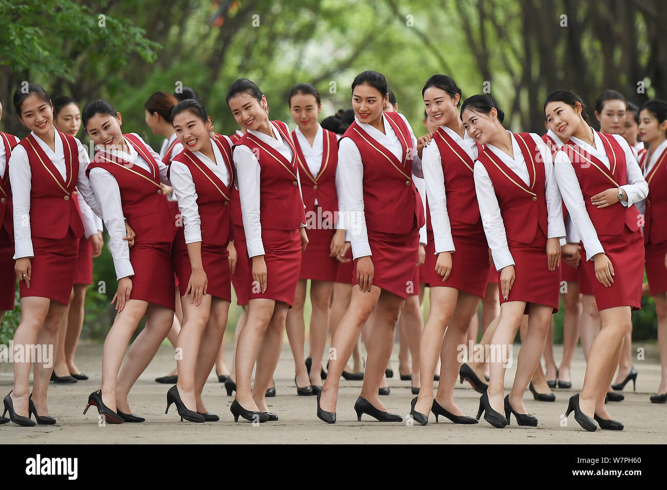 Female graduates of flight attendants major dressed in air hostess uniforms, pose for gradation photos in Taiyuan city, north China's Shanxi province, Stock Photo