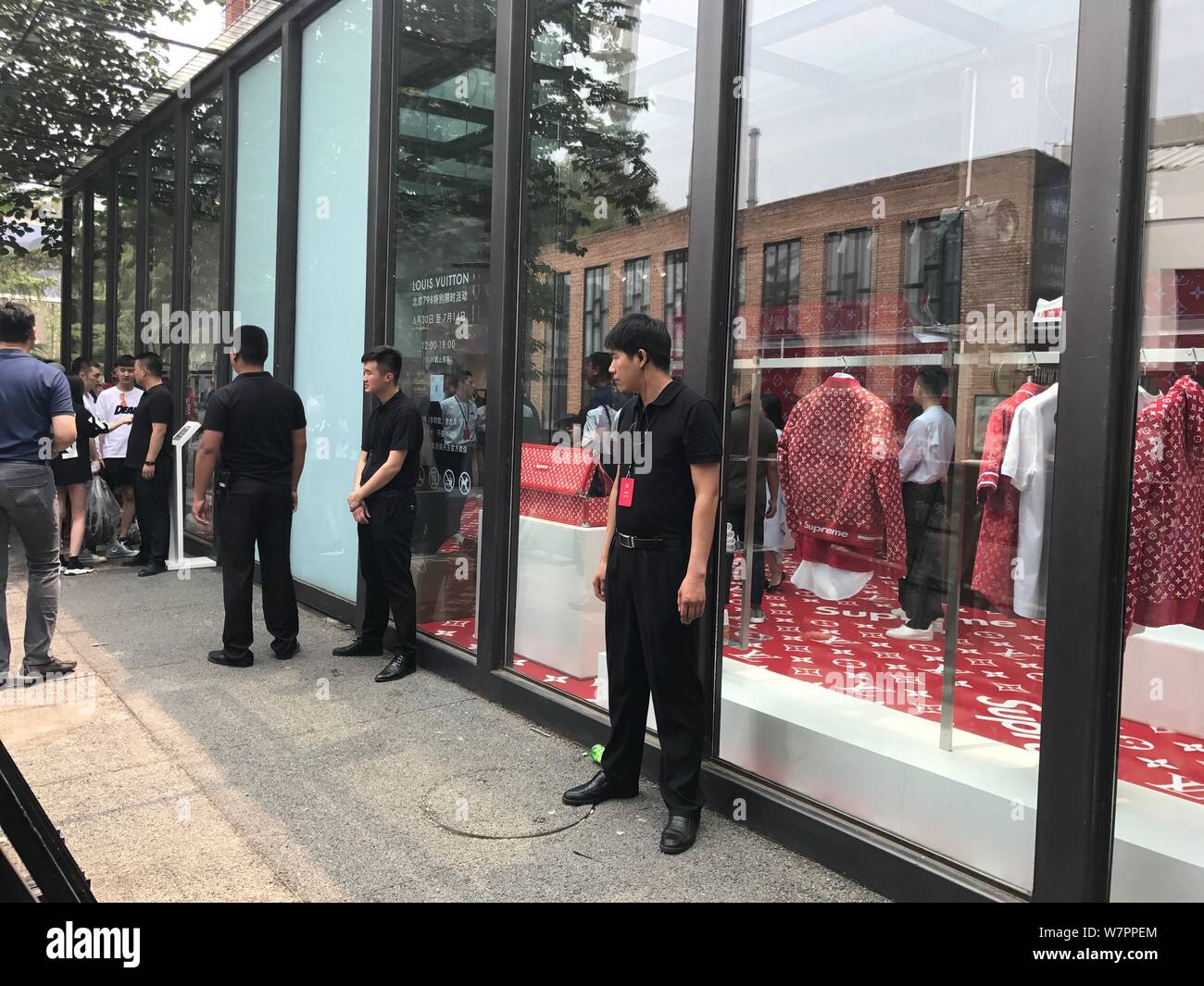 Security staffs stand guard in front of a boutique of Louis