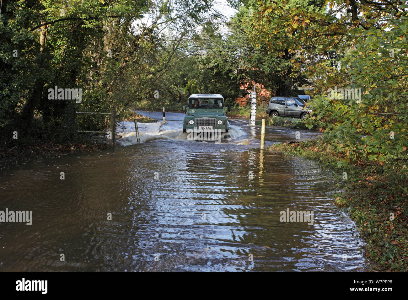 Landrover driving through the flooded ford over the Lin Brook stream, near Ringwood, Hampshire, England, UK, November 2012 Stock Photo