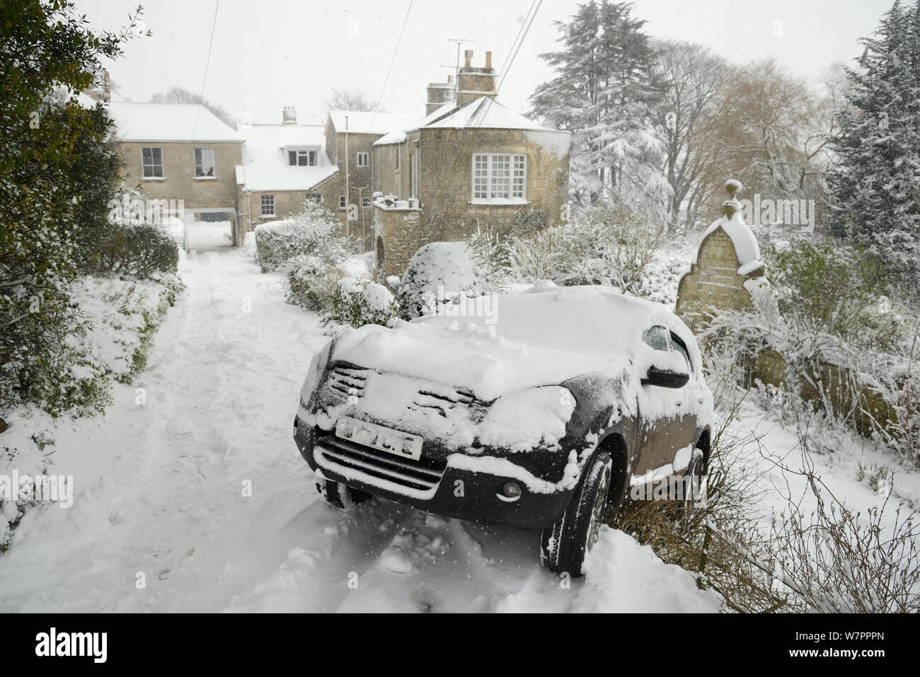 Car that has slid off driveway after losing traction on deep snow, Wiltshire, UK, January 2013 Stock Photo