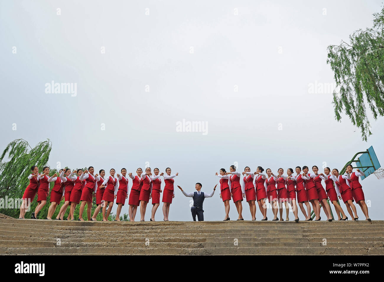 Female graduates of flight attendants major dressed in air hostess uniforms, pose for gradation photos in Taiyuan city, north China's Shanxi province, Stock Photo