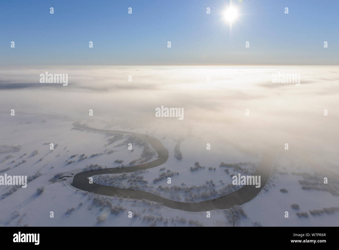 Aerial view over Suur-Emajagi river through the clouds. Estonia, winter  2011. Stock Photo