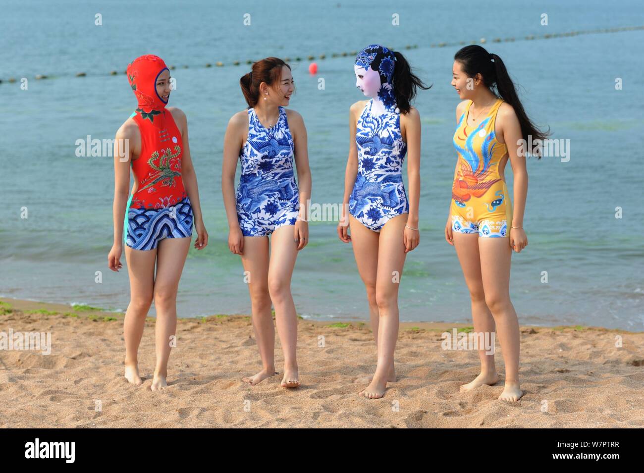 A model, second right, wearing a facekini swimsuit featuring blue-and-white  porcelain and embroidery is pictured at a beach resort in Qingdao city, ea  Stock Photo - Alamy