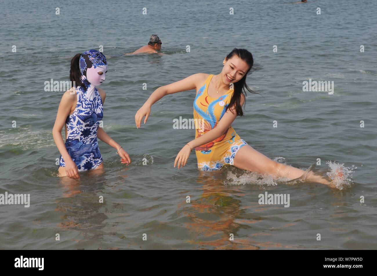 A model, left, wearing a facekini swimsuit featuring blueandwhite