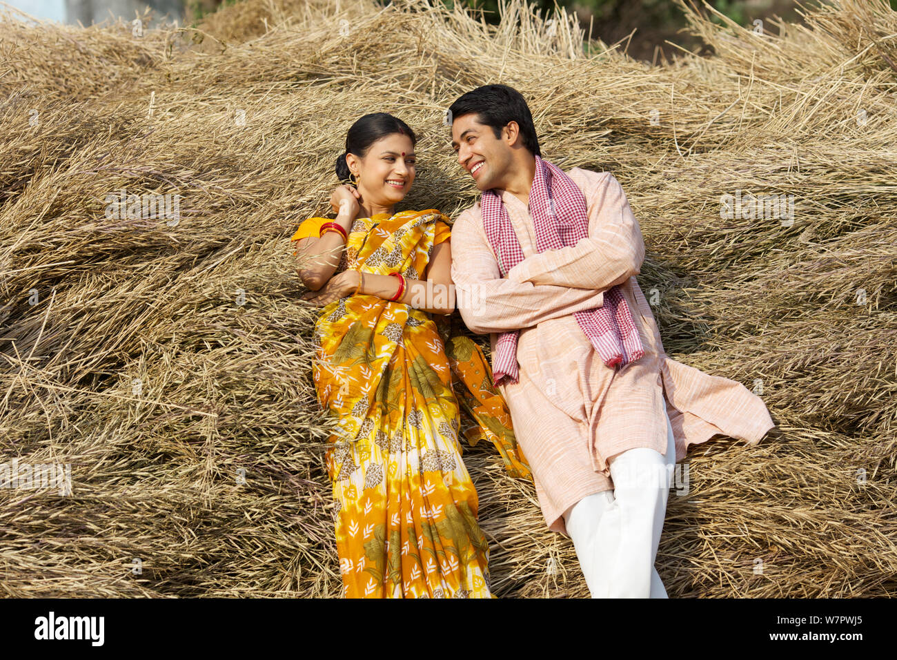 Rural couple lying against harvested crop Stock Photo - Alamy
