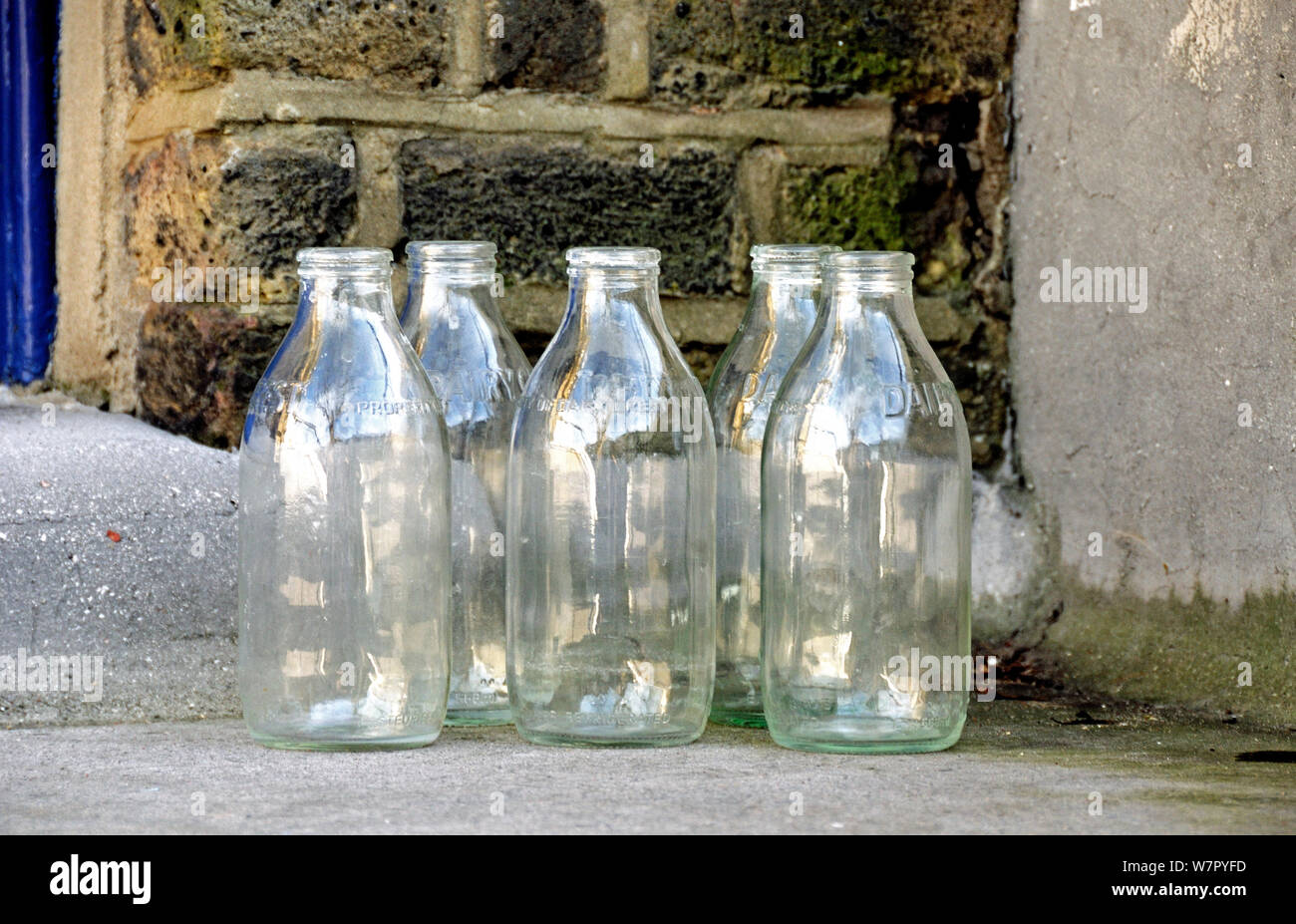 Five empty glass milk bottles on doorstep, Highbury, London Borough of Islington England UK Stock Photo