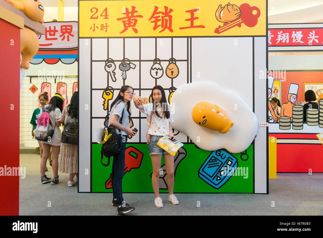 Cartoon enthusiasts take selfies with Gudetama, or lazy egg, created by Hello Kitty's developer Sanrio, in Shanghai, China, 19 June 2017.   The Japane Stock Photo