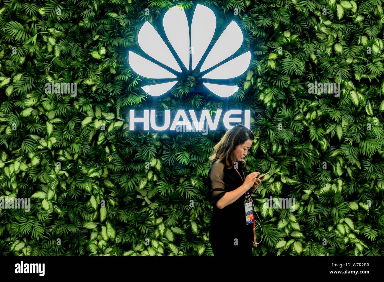 A visitor walks past the stand of Huawei during the 2017 Mobile World Congress (MWC) in Shanghai, China, 28 June 2017.   The Mobile World Congress 201 Stock Photo
