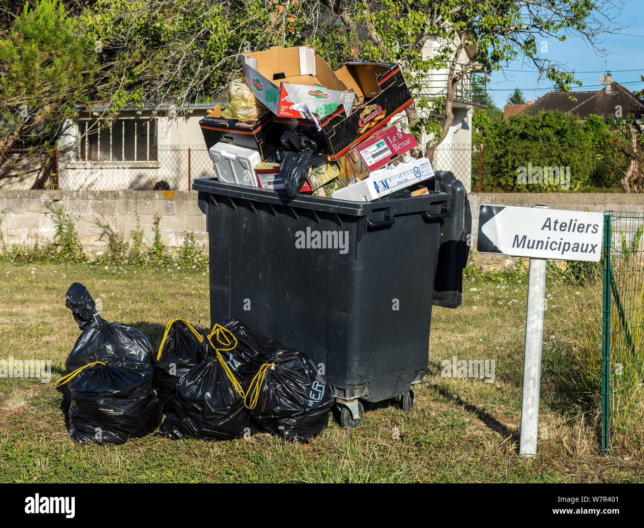 Overflowing public rubbish skip - France. Stock Photo