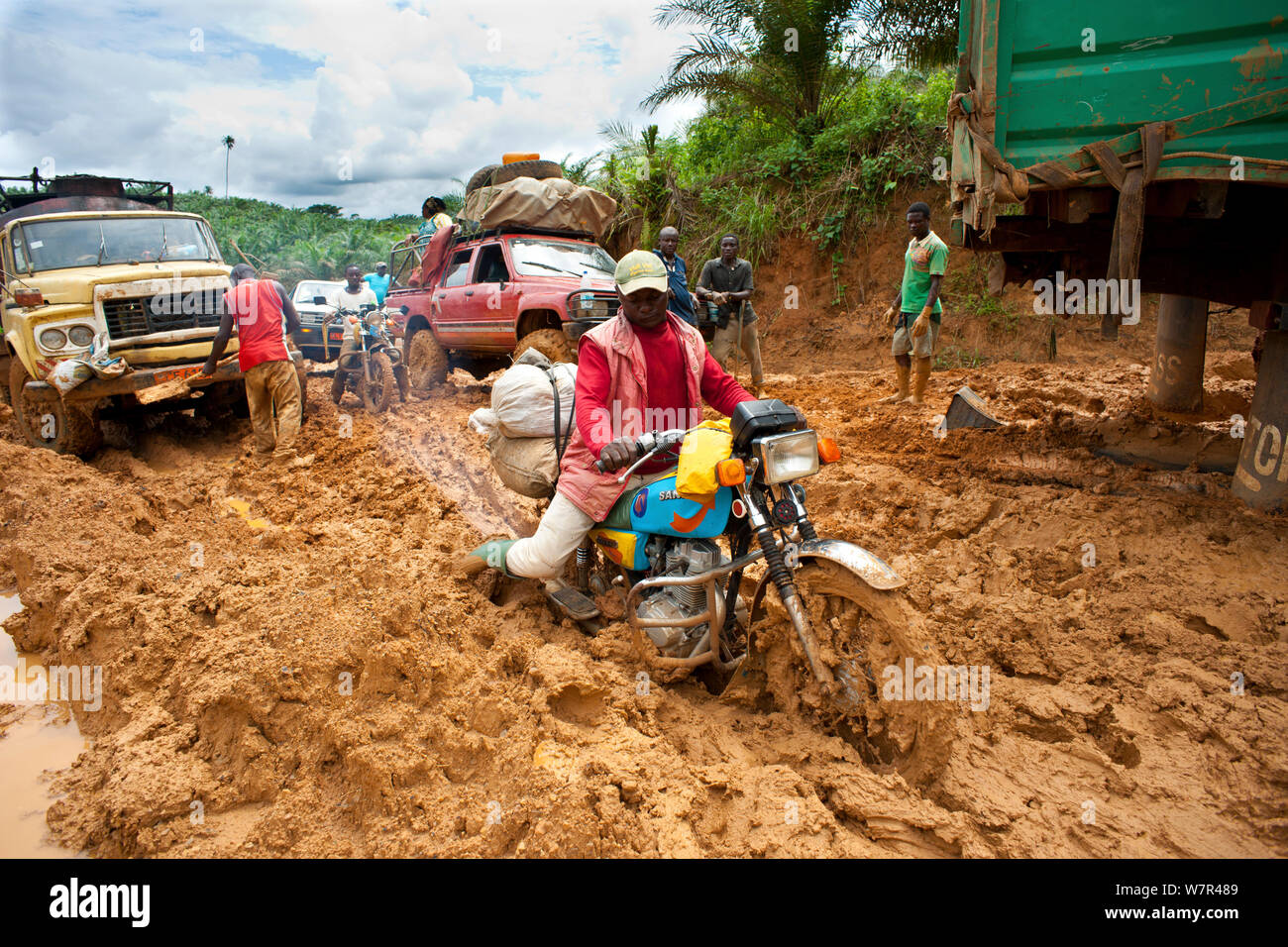 Vehicles stuck in deep mud - the onset of the rainy season deteriorates dirt roads making transport difficult, Cameroon, August 2009. Stock Photo