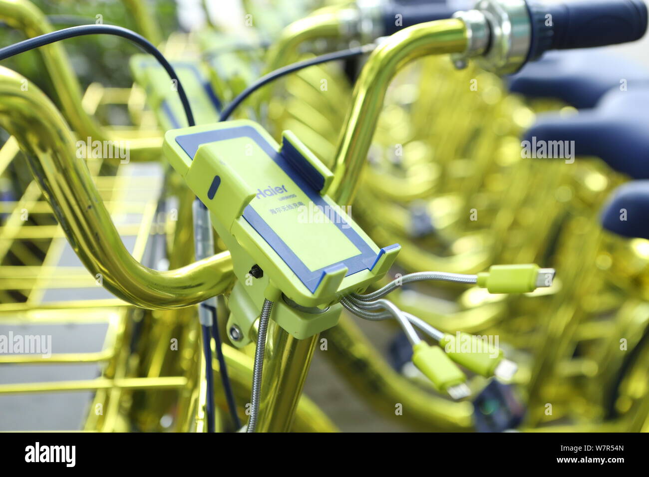 A phone holder is seen on a golden bicycle of Chinese bike-sharing service Coolqi in Shanghai, China, 8 June 2017.   The competition between shared bi Stock Photo
